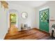 Inviting entryway with hardwood floors, a charming green door, a decorative mirror, and an arched doorway at 9390 W 14Th Ave, Lakewood, CO 80215