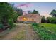 Charming single story home with a stone base and gravel driveway surrounded by mature trees and landscaping at dusk at 9390 W 14Th Ave, Lakewood, CO 80215