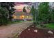 Charming single-story home with a stone base, gravel driveway and colorful front door set against a picturesque sunset at 9390 W 14Th Ave, Lakewood, CO 80215