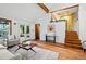 Spacious living room features vaulted ceilings, wood beams, and stairs leading to the upper level at 9390 W 14Th Ave, Lakewood, CO 80215