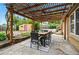 Outdoor dining area is set on a stone patio beneath a wooden pergola covered with lights at 9390 W 14Th Ave, Lakewood, CO 80215