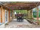 Outdoor patio area features a dining table beneath a stylish pergola adorned with string lights at 9390 W 14Th Ave, Lakewood, CO 80215