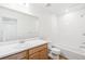Clean bathroom with single sink, tub, and tiled shower at 13402 E 110Th Way, Commerce City, CO 80022