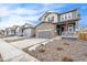 Two story house on a tree lined street with gray siding and stone accents at 13402 E 110Th Way, Commerce City, CO 80022