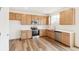 L-shaped kitchen with stainless steel appliances and light wood cabinets at 13402 E 110Th Way, Commerce City, CO 80022