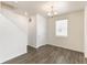 Hallway with hardwood floors, modern lighting fixture, and neutral walls at 816 Leeward St, Lochbuie, CO 80603
