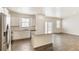 Bright, open kitchen features white cabinets, granite countertops, stainless steel appliances and hardwood floors at 816 Leeward St, Lochbuie, CO 80603