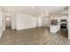 Open-concept living area featuring hardwood floors, white walls, and stainless steel appliances at 816 Leeward St, Lochbuie, CO 80603