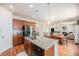 Open kitchen with granite island, dark appliances, wood cabinets, and hardwood flooring at 3406 Quicksilver Rd, Frederick, CO 80516