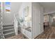 Hallway featuring a staircase, decorative table, and interior door for easy access to other living spaces at 10062 Southlawn Cir, Commerce City, CO 80022