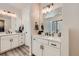 Modern bathroom with dual sinks, white cabinetry, and black hardware fixtures at 5134 Queen Ct, Arvada, CO 80002