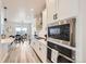 Modern kitchen with white cabinets, stainless steel appliances, and dining area views at 5134 Queen Ct, Arvada, CO 80002