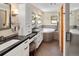 Well-lit bathroom with a soaking tub, dual sinks, and modern fixtures at 1121 S Williams St, Denver, CO 80210