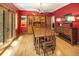 Dining room features hardwood floors, red walls, and cabinet next to french doors at 1121 S Williams St, Denver, CO 80210