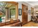 Elegant foyer featuring hardwood floors, vintage piano, and natural light from a large window at 1121 S Williams St, Denver, CO 80210
