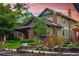 Charming two-story home featuring a landscaped front yard, brick accents, and classic architectural details under a beautiful sunset sky at 1121 S Williams St, Denver, CO 80210