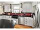 Modern kitchen boasts white cabinets, black countertops, and stainless steel appliances at 1121 S Williams St, Denver, CO 80210