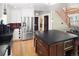 Open concept kitchen with stainless steel refrigerator, dark countertops and wood flooring at 1121 S Williams St, Denver, CO 80210