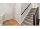 Bright entryway featuring hardwood floors, a coat closet, and a staircase with carpeted steps and a wooden handrail at 359 Wessex Cir, Highlands Ranch, CO 80126