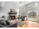 Inviting living room with vaulted ceilings, a brick fireplace, hardwood floors, and access to the backyard at 359 Wessex Cir, Highlands Ranch, CO 80126