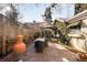 Landscaped brick patio with dining set, large decorative pot, and a wooden fence and pergola at 1602 Glen Bar Dr, Lakewood, CO 80215