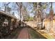 Narrow backyard with a brick path, greenery, wooden fences, and mature trees at 1602 Glen Bar Dr, Lakewood, CO 80215