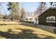 Landscaped backyard featuring lush green grass, mature trees, and a charming home exterior covered in ivy at 1602 Glen Bar Dr, Lakewood, CO 80215