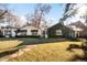 Charming home featuring a manicured lawn, mature trees, and an ivy-covered exterior at 1602 Glen Bar Dr, Lakewood, CO 80215