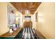 Charming hallway with a wooden ceiling, black and white tile floor, and vintage furnishings, creating a unique and inviting space at 1602 Glen Bar Dr, Lakewood, CO 80215