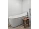 Elegant bathroom featuring a freestanding tub, wooden stool and textured white walls at 2725 6Th St, Boulder, CO 80304