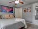 Cozy bedroom features ceiling fan, plush carpet, and a comfortable bed with decorative pillows and throw blanket at 1275 S Wolff St, Denver, CO 80219