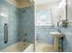 Classic bathroom featuring blue tiling, a pedestal sink, and a shower-tub combination at 409 Lookout View Dr, Golden, CO 80401