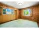 Wood-paneled bedroom with natural light and green carpet, offering a peaceful retreat at 409 Lookout View Dr, Golden, CO 80401