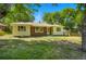 Charming yellow one-story home with brick accents and a well-manicured lawn surrounded by mature trees at 409 Lookout View Dr, Golden, CO 80401