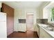 Retro kitchen with brick accent wall, white cabinets, patterned backsplash, and stainless steel sink at 409 Lookout View Dr, Golden, CO 80401