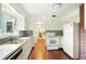 Galley-style kitchen with white cabinets, mosaic backsplash, stainless steel sink, and vintage appliances at 409 Lookout View Dr, Golden, CO 80401