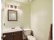 Neat half-bathroom featuring a vanity with a sink, toilet, a mirror, and a light fixture at 12013 W 56Th Cir, Arvada, CO 80002