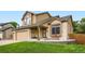 Charming two-story home featuring a covered front porch, stone accents, and well-manicured lawn at 12013 W 56Th Cir, Arvada, CO 80002
