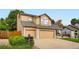 Two-story home showcasing a large two-car garage, neutral siding, and manicured lawn at 12013 W 56Th Cir, Arvada, CO 80002