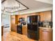 Modern kitchen featuring warm wood cabinetry, stainless steel appliances, and hardwood floors at 12013 W 56Th Cir, Arvada, CO 80002