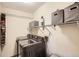 Functional laundry room featuring modern washer/dryer, storage shelves, and ample space at 12013 W 56Th Cir, Arvada, CO 80002