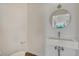Modern powder room with floating sink, round mirror, and hardwood floors at 1231 Newton St, Denver, CO 80204