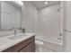 Modern bathroom with shower and tub combination, tiled walls, and dark wood vanity at 1231 Newton St, Denver, CO 80204