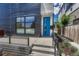 Modern home featuring a sleek exterior, a vibrant blue front door, and manicured landscaping at 1231 Newton St, Denver, CO 80204