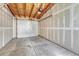 Spacious unfinished garage with concrete floors and wood-framed ceiling with electric garage door opener at 1231 Newton St, Denver, CO 80204