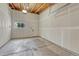 Spacious unfinished garage with concrete floors, wood-framed ceiling, window, and a door at 1231 Newton St, Denver, CO 80204