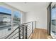 Modern hallway featuring wooden floors, steel banisters, and multiple windows at 1231 Newton St, Denver, CO 80204