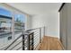 Bright hallway featuring hardwood floors, modern railing, and natural light streaming through the window at 1231 Newton St, Denver, CO 80204