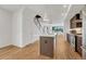 Bright, modern kitchen with stainless steel appliances, center island, and open floor plan to the stairwell at 1231 Newton St, Denver, CO 80204