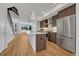 Modern kitchen featuring stainless steel appliances, a center island, and wooden floors with a view of the entry way at 1231 Newton St, Denver, CO 80204